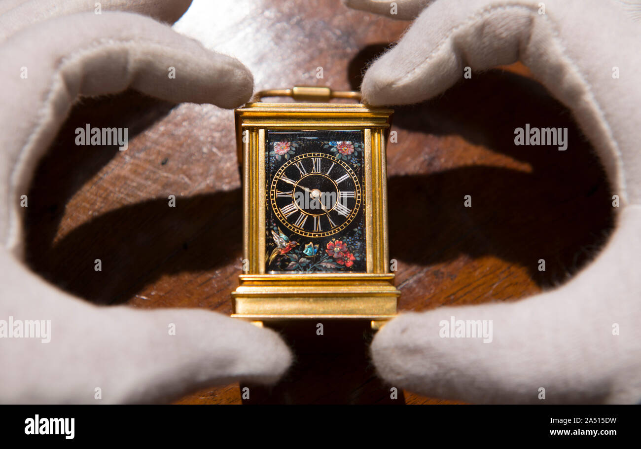 Howard Walwyn, London, UK. 17th October 2019. Rare clocks by some of the best 17th & 18th century English makers are prepared for exhibition in early November. Image: An exquisite French gilt miniature carriage timepiece with unusual Limoges porcelain panels on all four sides, circa 1880. Credit: Malcolm Park/Alamy Live News. Stock Photo