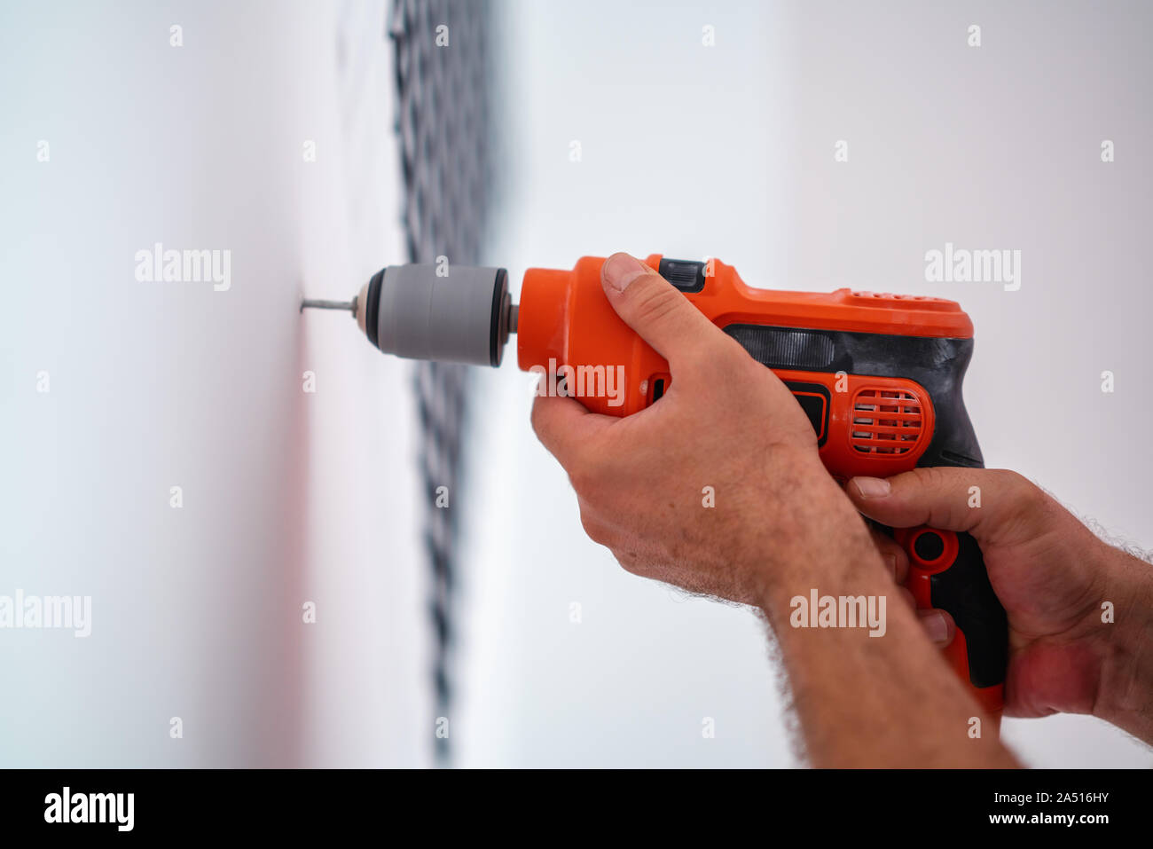 Drilling a hole on the wall for construction or renovation. Stock Photo