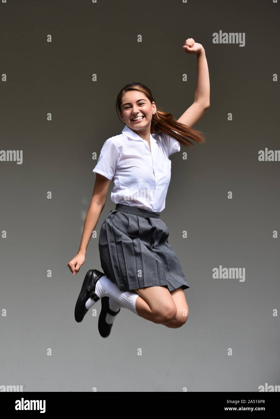 An Excited Female Teenager Jumping Stock Photo