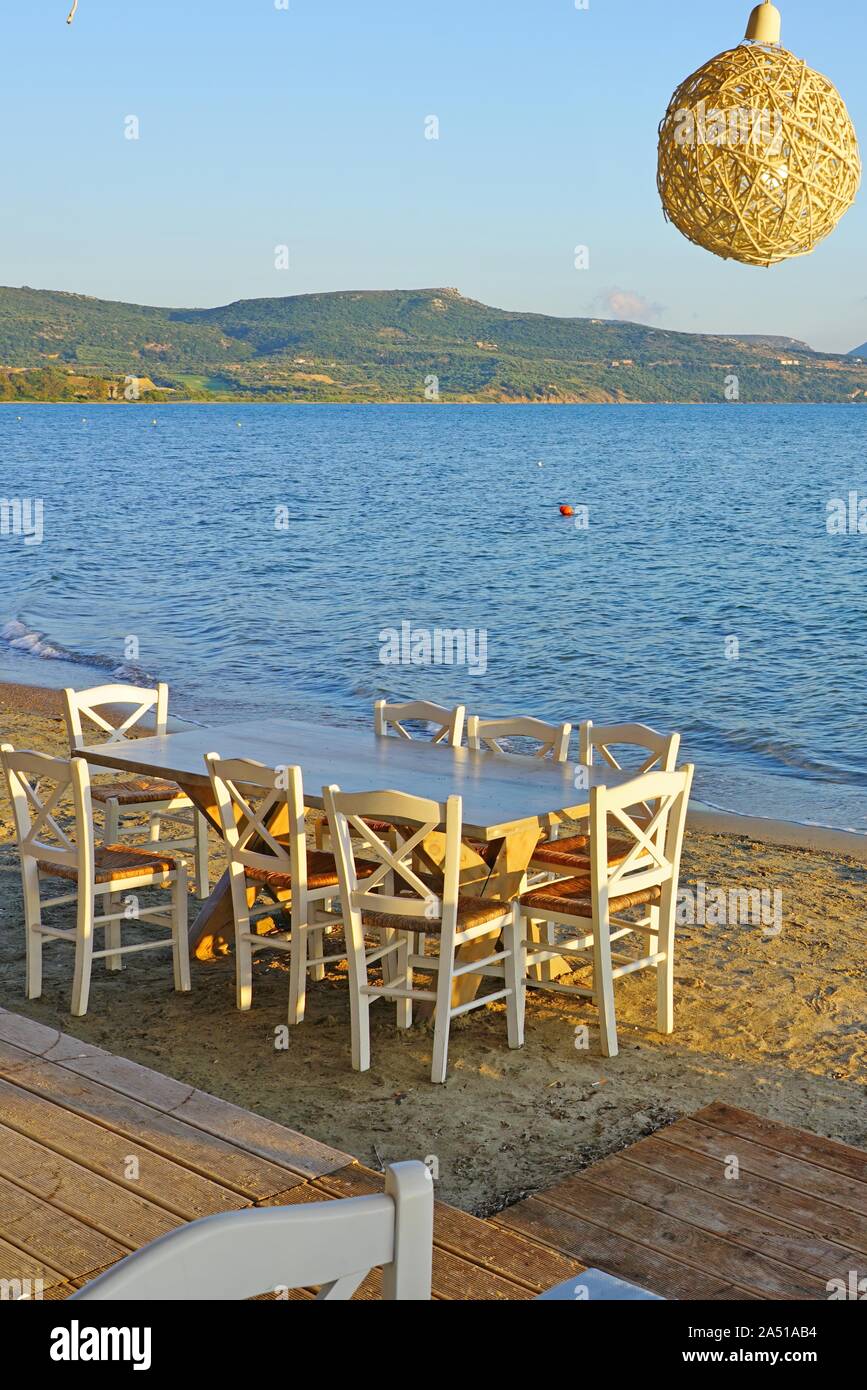 Table set on the beach at a traditional Greek taverna in Gialova on the Navarino Bay in Messinia in the Peloponnese region of Greece near Pylos Stock Photo