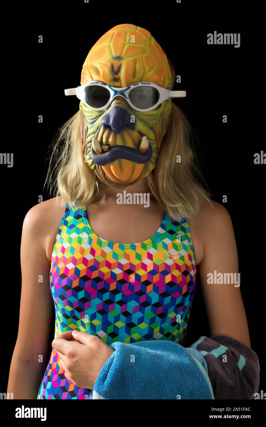 teenage girl dressed in halloween costume in swimsuit and mask Stock Photo