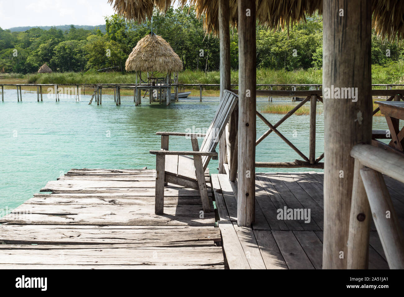 Lake dock with chair at a sunny day, El Remate, Guatemala Stock Photo