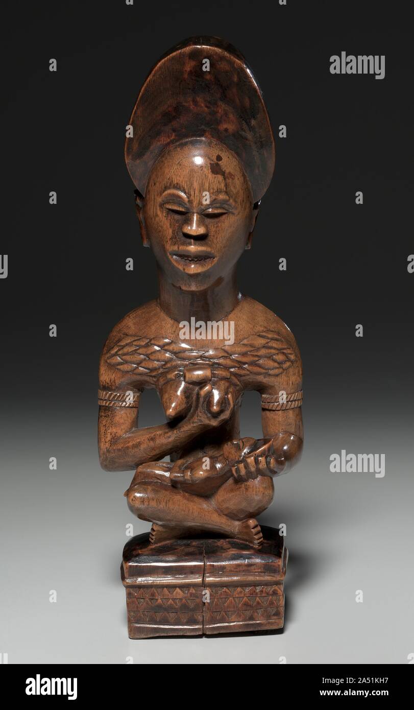 Mother-and-Child Figure , mid to late 1800s. This mother-and-child figure was probably part of a cult concerned with the treatment of infertility. Both her jewelry and her seated pose indicate that the woman occupied a high rank in her community. Her miter-shaped hairstyle, chiseled teeth, and raised body scars--considered to be marks of beauty and perfection--signal that the woman incarnates the founding ancestor of a kinship group. Stock Photo