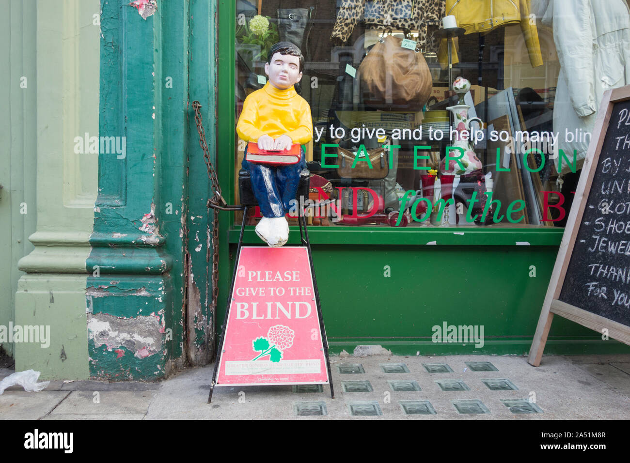 Please Give To The Blind collection box and figure outside a charity