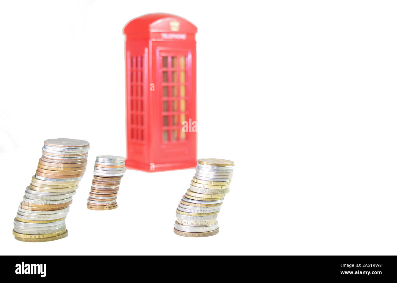 UK Brexit. piles of coins with an with a phone booth in the background out of focus on an overexposed white background. Brexit concept Stock Photo