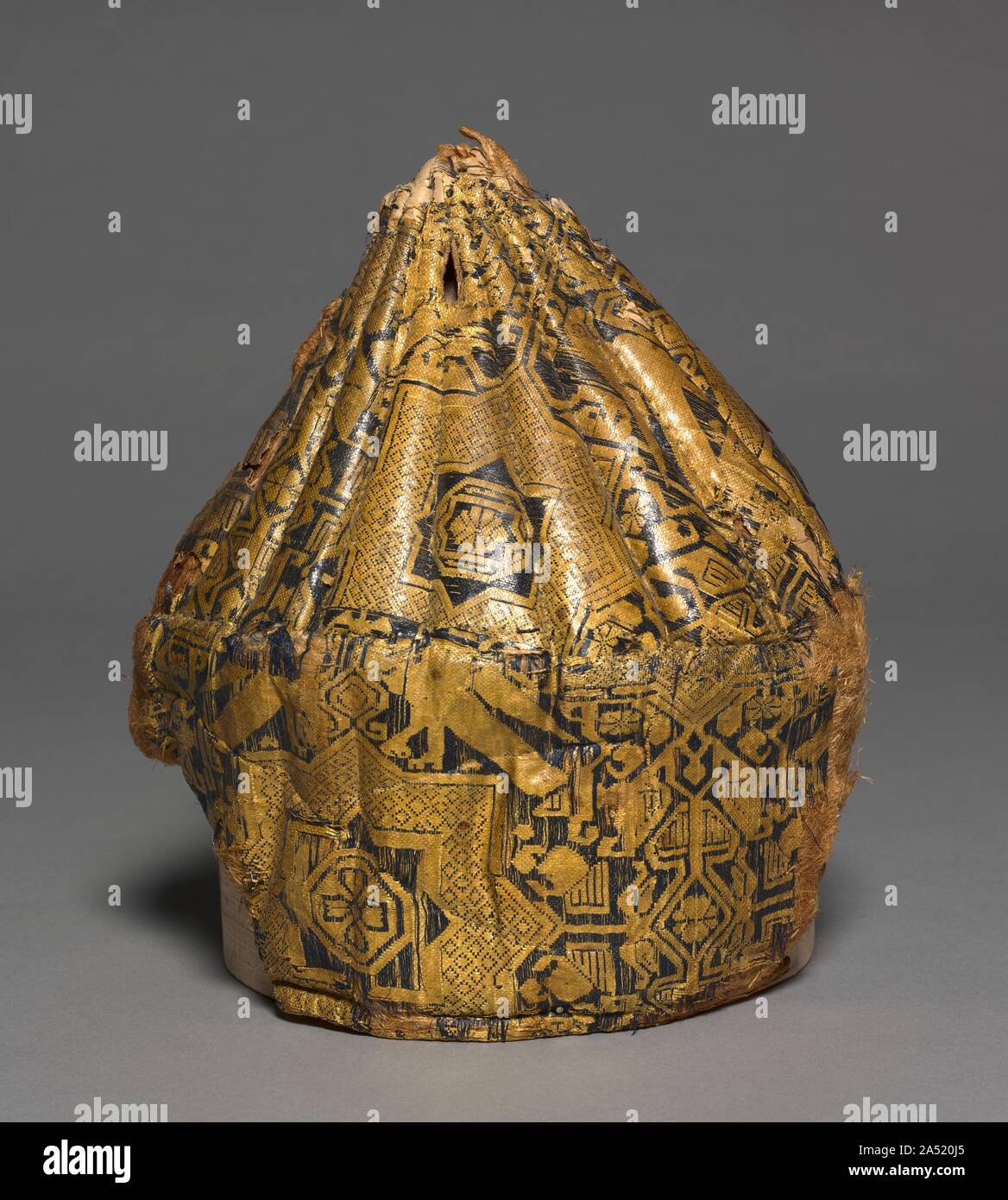 Quilted cap with star-patterned silk, 1000s. This quilted hat is one of a number of hats that have been recovered from Egyptian graves. It consists of silk sewn to a heavily quilted form, the top part of which is ribbed. The design of the silk is based on an eight-pointed star with paired birds above and stylized palmettes in the interspaces. Such hats were worn with or without a turban by persons of ranks. Stock Photo