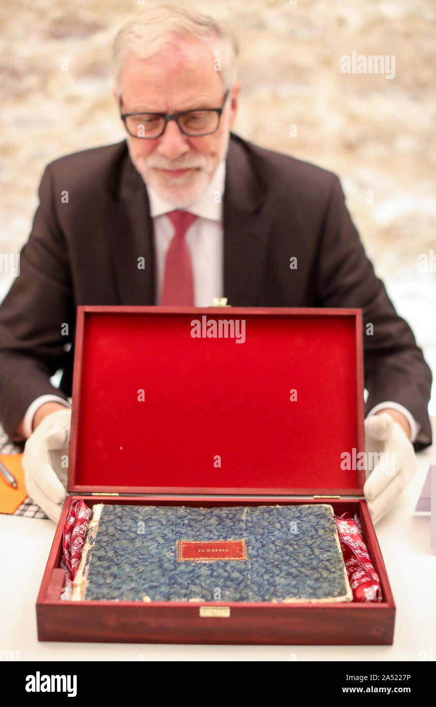 17 October 2019, Saxony-Anhalt, Halle: Rainer Robra (CDU), Minister of Culture of Saxony-Anhalt, presents a lost manuscript of the score by Georg Friedrich Händel. This is the score manuscript of the first performance of the oratorio 'Messiah' outside Great Britain and Ireland. As the foundation announced on Thursday, there are 102 bound sheets with notes of the famous work, which was performed in Italian translation as 'Il Messia' and in an arrangement between 1768 and 1772 in Florence. According to the Händel-Haus Foundation, it has one of the most comprehensive and important music collectio Stock Photo