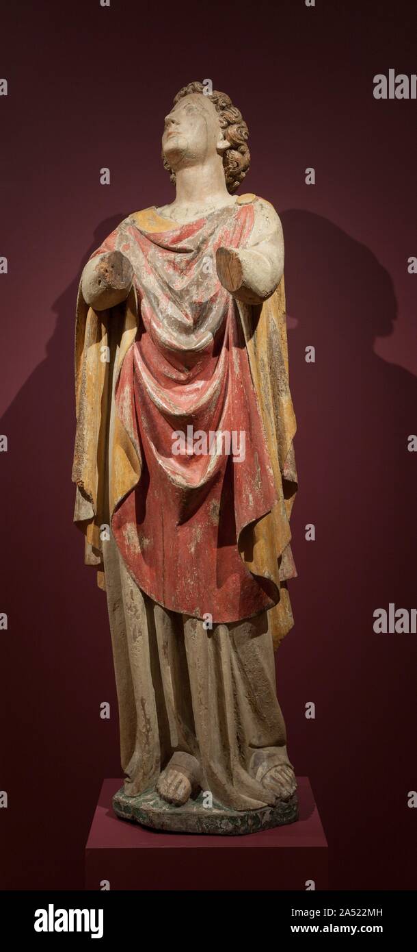 Saint John the Evangelist, c. 1400. This sculpture was originally part of a life-sized Crucifixion group and intended to be seen with two more statues, a crucified Christ and a standing Virgin. Multi-figured ensembles in wood belong to a vigorous tradition in central Italy extending from the 1200s to the 1400s. Most commonly, these groups represent the Deposition (Christ being lowered from the cross) or the Lamentation (Mary cradling the dead Christ on her lap). Crucifixion groups consisted of a central sculpture of Christ on the cross flanked on his right by the Virgin Mary and on his left by Stock Photo