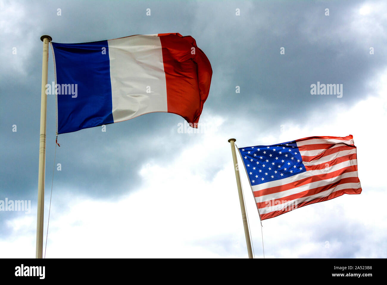 FRENCH AND AMERICAN FLAGS FLUTTERING IN THE WIND Stock Photo