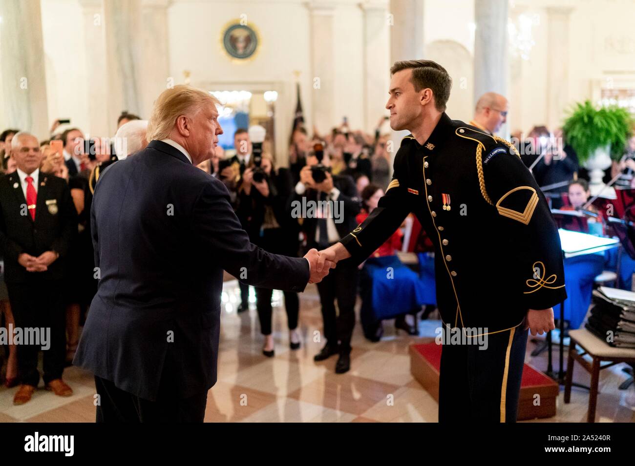 Washington, United States of America. 16 October, 2019. U.S President Donald Trump, left, thanks Staff Sgt. Christian Douglas Hoff, right, of the U.S. Army Choir for his performance during a reception in honor of Italian President Sergio Mattarella in the Grand Foyer of the White House October 16, 2019 in Washington, DC. Credit: Andrea Hanks/White House Photo/Alamy Live News Stock Photo
