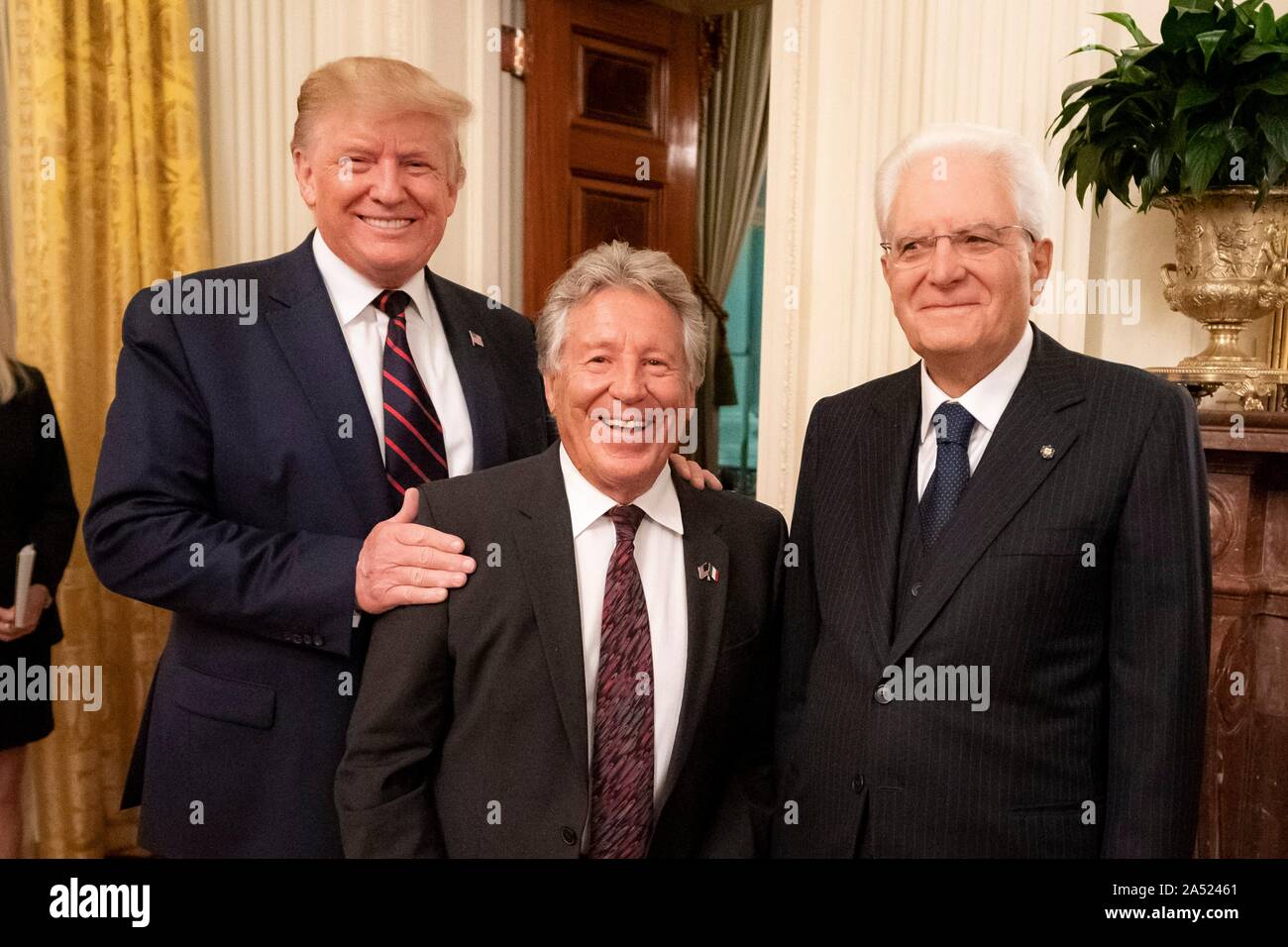 Washington, United States of America. 16 October, 2019. U.S President Donald Trump, left, poses with legendary race car driver Mario Andretti and Italian President Sergio Mattarella, right, during a reception in the East Room of the White House October 16, 2019 in Washington, DC. Credit: Tia Dufour/White House Photo/Alamy Live News Stock Photo