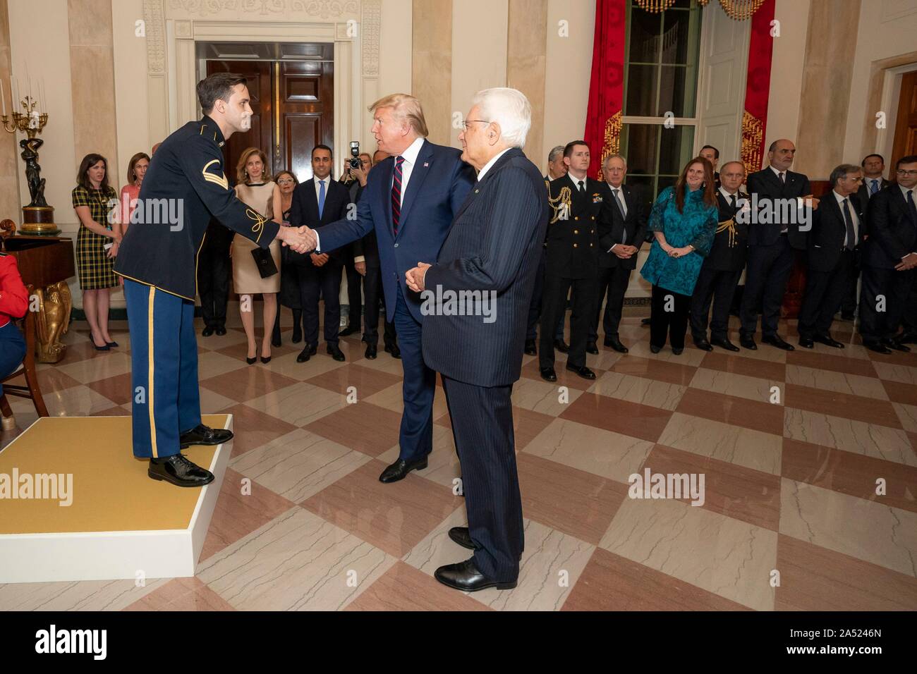 Washington, United States of America. 16 October, 2019. U.S President Donald Trump, center, thanks Staff Sgt. Christian Douglas Hoff, left, of the U.S. Army Choir for his performance during a reception in honor of Italian President Sergio Mattarella, right, in the Grand Foyer of the White House October 16, 2019 in Washington, DC. Credit: Tia Dufour/White House Photo/Alamy Live News Stock Photo