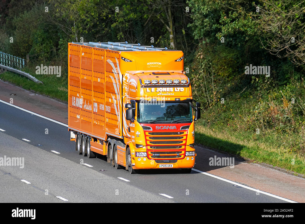 L.E.JONES Hauliers; Motorway heavy bulk Haulage delivery trucks, haulage, lorry, transportation, truck, special cargo, Yellow Orange Scania R580 vehicle, delivery, transport industry freight on the M6 at Lancaster, Stock Photo