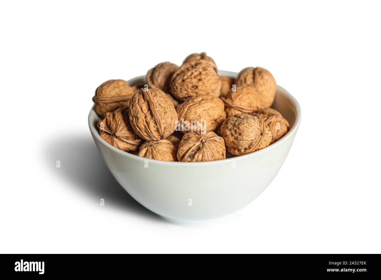 White bowl full of nuts on a white background Stock Photo