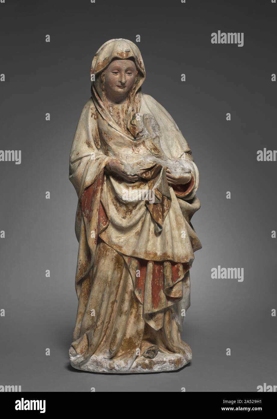 Standing Virgin, c. 1440-1450. This standing Virgin now lacks the child she once cradled in her left arm. The sculpture may have been damaged in the French Revolution by falling onto its face. It was carved from soft white limestone of a type known to be quarried at Asni&#xe8;res-l&#xe8;s-Dijon, near Champmol. The figure recalls many of the hallmarks of the style of Claus de Werve, a Netherlandish artist active at the court of Burgundy. The Virgin has a sweet, round face that is also smooth and fleshy, her eyelids droop pensively and she is engulfed in rich voluminous draperies that cascade in Stock Photo