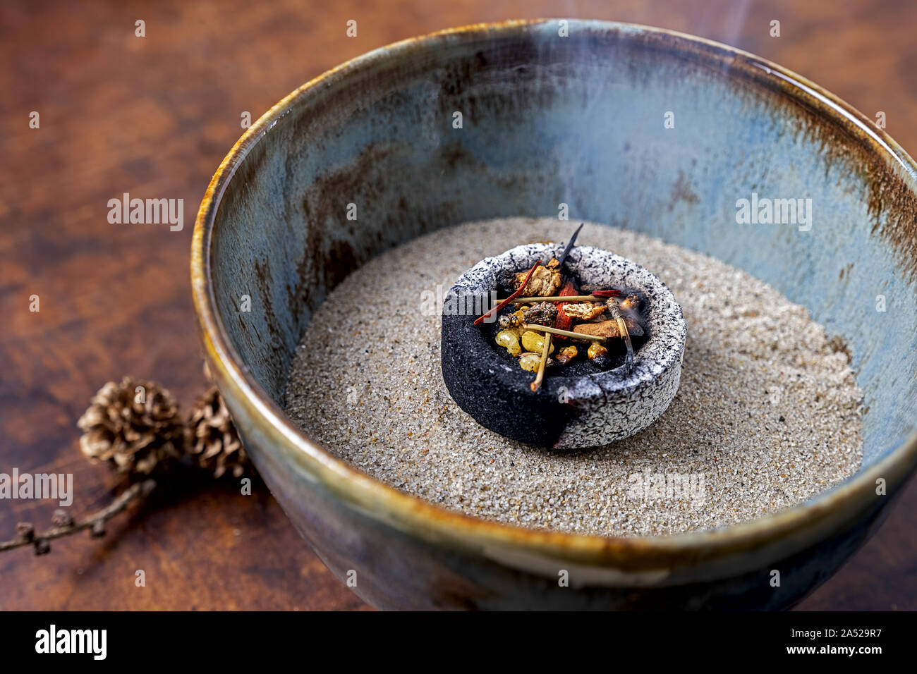 incense, ceramic bowl filled with sand, glowing coal and a mixture of