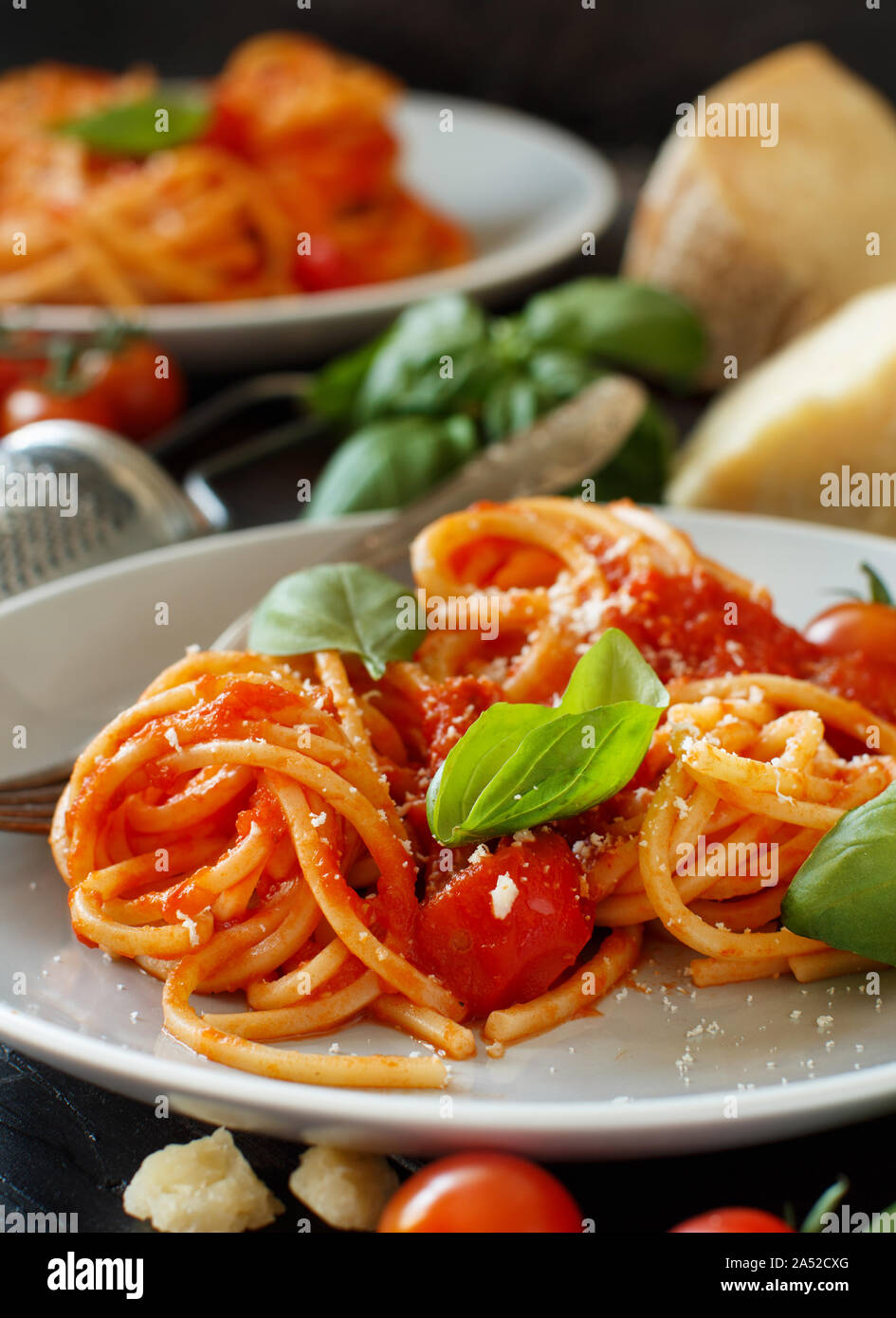 Spaghetti pasta with tomato sauce, basil and cheese on a wooden table Stock Photo