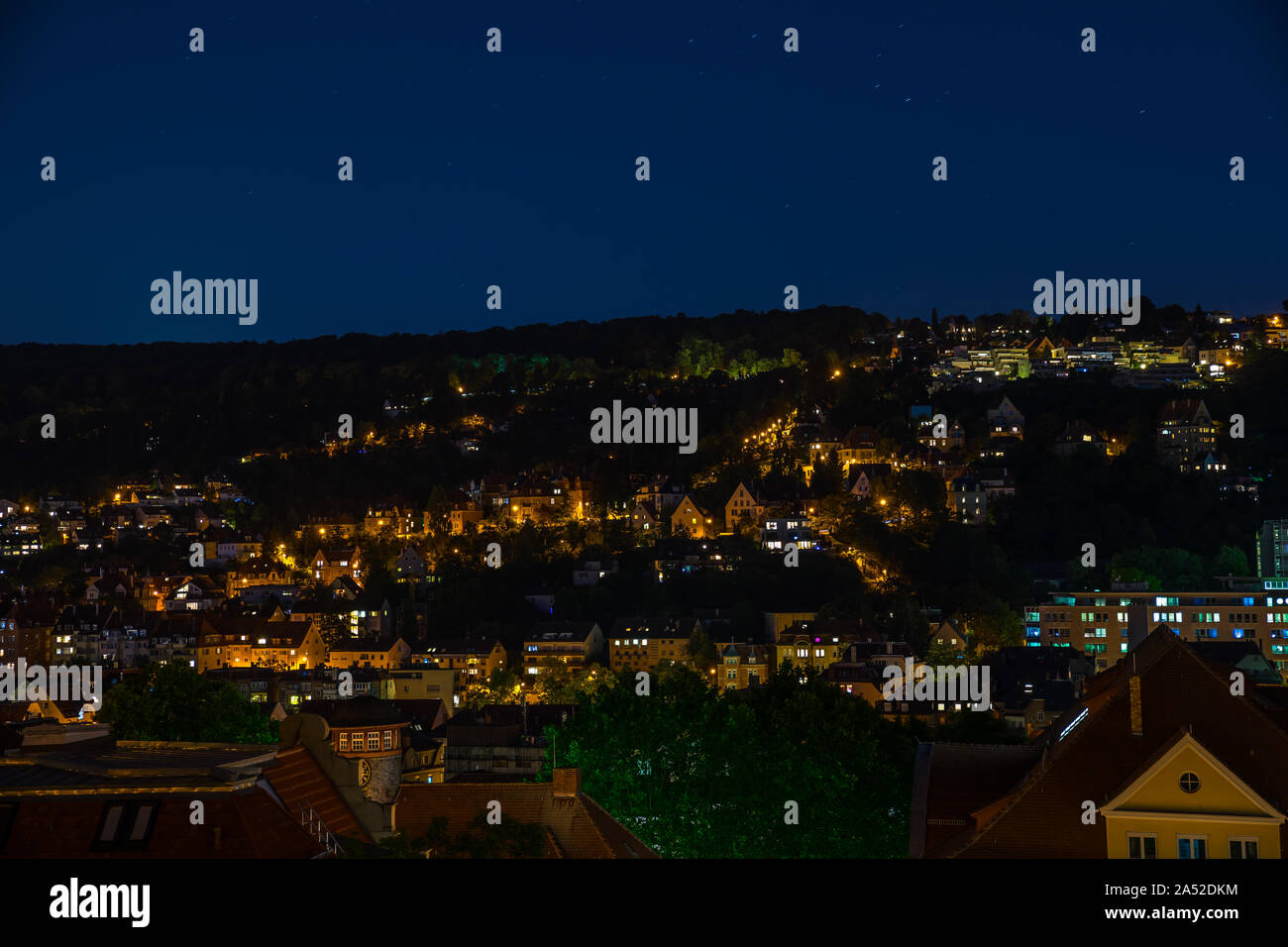 Germany, Starry sky in the night over illuminated stuttgart heslach houses and roofs aerial view over skyline by night Stock Photo