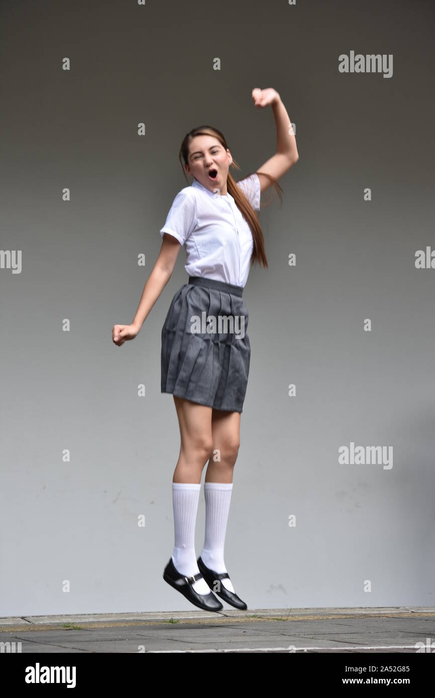 An Excited Female Teenager Jumping Stock Photo