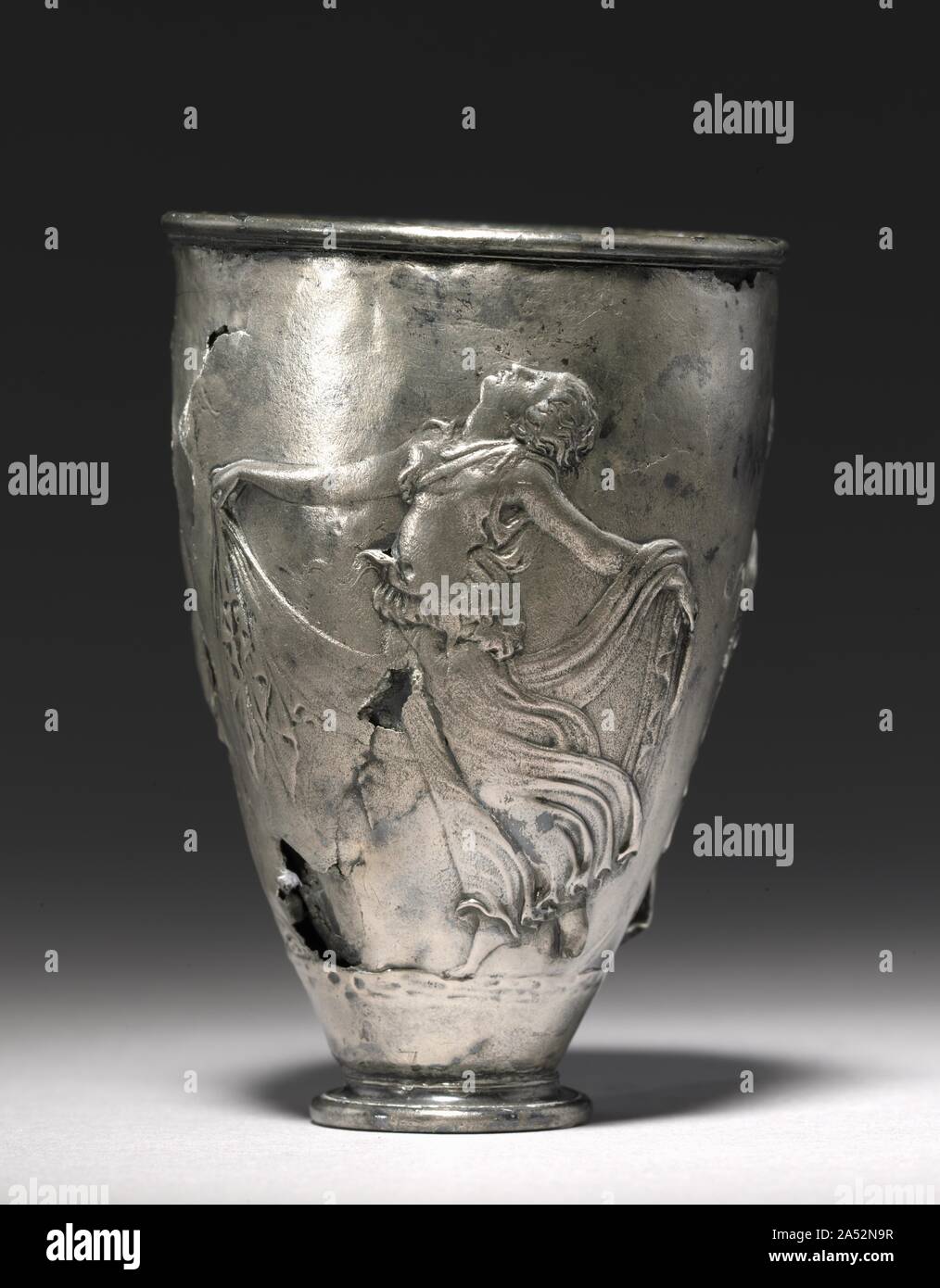 The Vicarello Goblet, late 1st Century BC - early 1st Century. This masterpiece of the Roman silversmith&#x2019;s art was found north of Rome at Vicarello, the ancient Aquae Apollinares (the Springs of Apollo). Exquisitely worked in relief is a multifigure scene centered on a rustic shrine of the god Priapus. He is in the form of a stylized boundary marker placed atop a column. A woman approaching from the right seems to have brought him to life by touching him. To the left are votive offerings to the god arranged on top of and around a table. A satyr at the far left and a maenad at the far ri Stock Photo