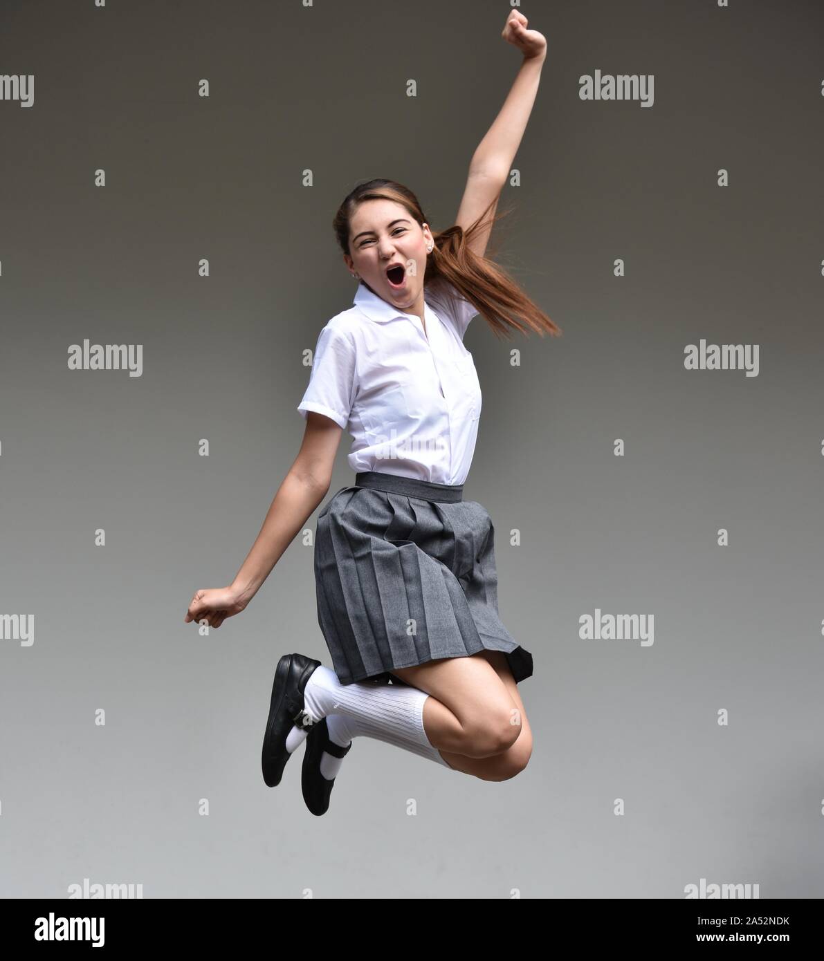 An Excited Female Teenager Jumping Stock Photo