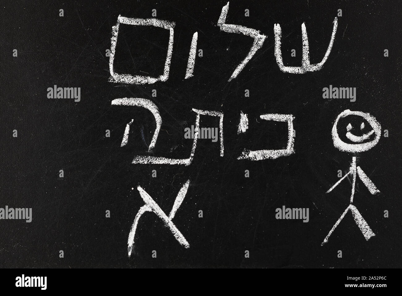 Back to School. Blackboard or chalkboard with Hello First Grade class greetings in Hebrew Shalom Kita Alef written with white chalk on the black board. Stock Photo