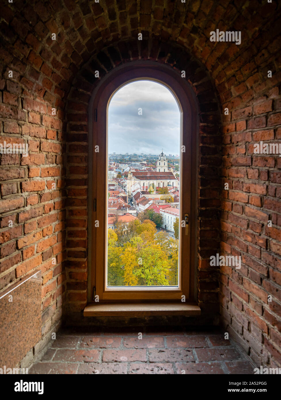 View through a window of the historic Gediminas tower across Old Town and a church in Vilnius, Lithuania Stock Photo