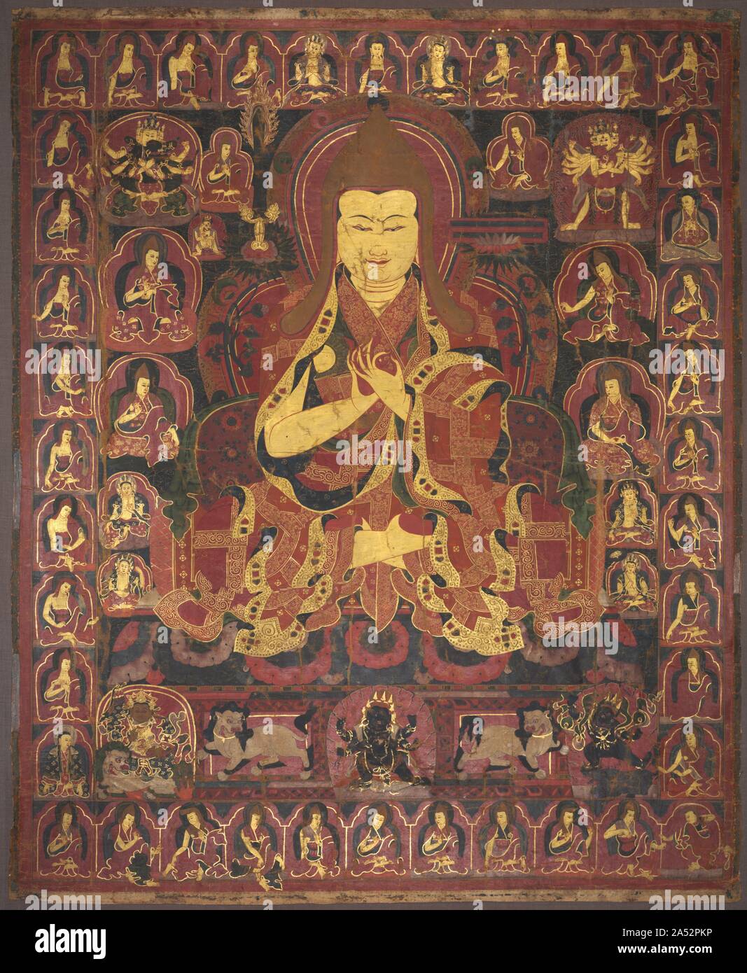 Tsong Khapa, Founder of the Geluk Order, c. 1440-1470. The Buddhist order to which the Dalai Lamas belong was founded by Tsong Khapa (1357-1419), whose image is seen here as the large central figure holding his hands in the teaching mudra. He wears the pointed golden hat that is the insignia for monks of the Geluk order. At the level of his ears are the sword and book, emblems of Manjushri, the bodhisattva of wisdom. These emblems allude to the Tibetan Buddhist tradition that accorded Tsong Khapa the status of being an emanation of Manjushri.  This extraordinary, sumptuously rendered painting, Stock Photo