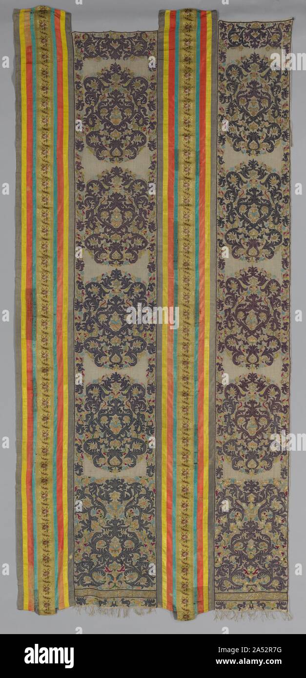 Two Parts of a Curtain, 1700s. During the 1700s, stunning large embroidered door curtains such as these hung across doorways onto interior courtyards of multistoried residences. Light entered through their loosely woven linen ground while the reversible embroidered decoration provided beauty and privacy. Such curtains have three embroidered widths, the third missing here, joined by colourful plain silk ribbons flanking a French floral ribbon in the center. Stock Photo