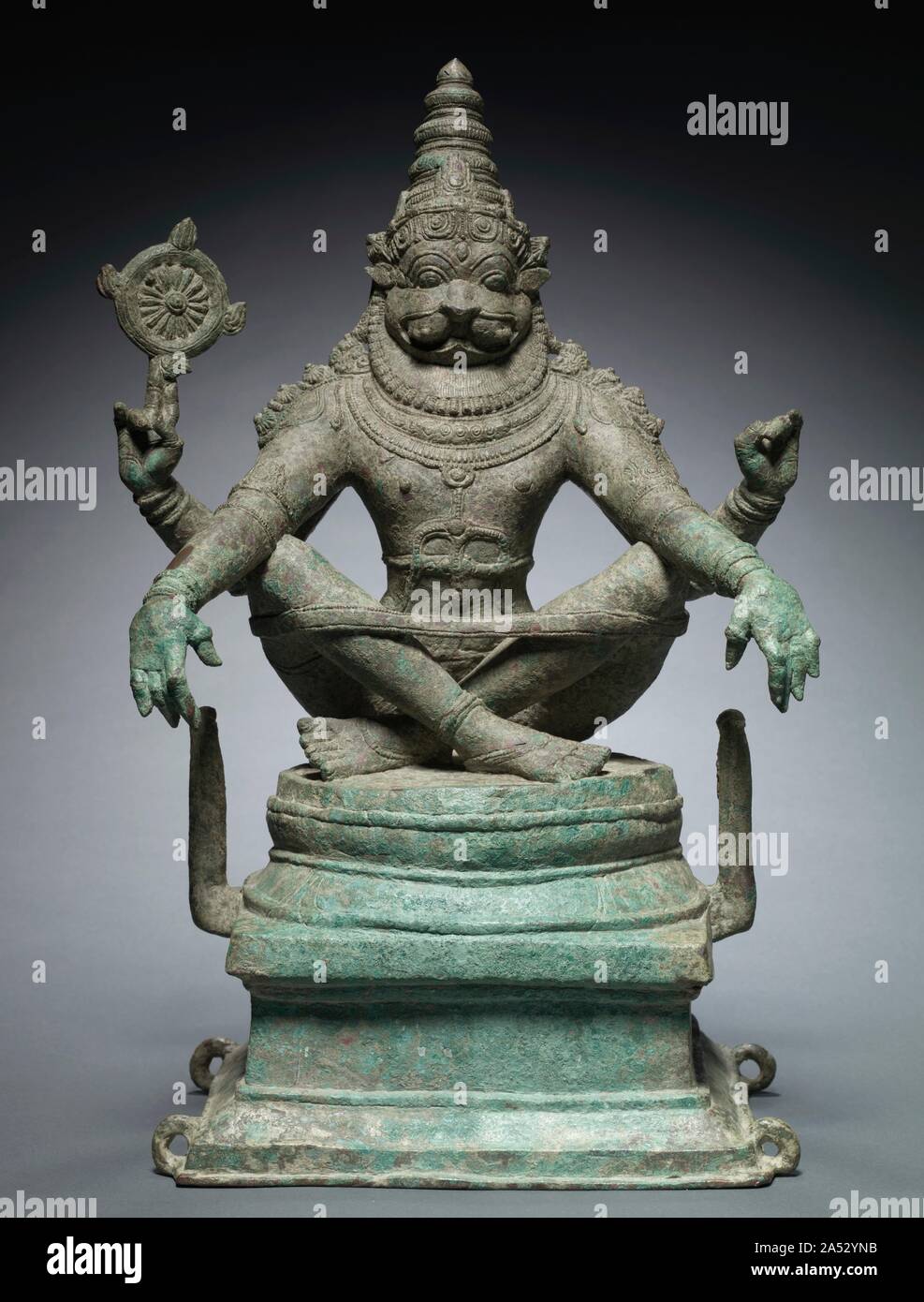Yoga Narashimha, Vishnu in his Man-Lion Avatar, c. 1250. Narasimha means &quot;man-lion&quot; in Sanskrit, and is the name of one of the ten main avatars, or incarnations, of the Hindu god Vishnu. For devotees, the man-lion form recalls a myth that describes his superhuman defeat of a seemingly invincible demonic foe.   This rare iconic form also embodies royal power and yogic discipline. The intensity of his concentration is apparent in the expression of his face over the ruff of mane, the taut posture, symmetry, and perfect proportions of his four-armed body. The yoga band holds the crossed Stock Photo