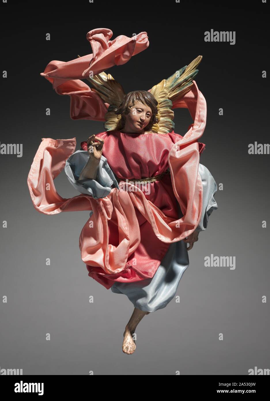 Figure from a Cr&#xe8;che: Angel, 1780-1830. The practice of creating scenes of the Nativity for the home dates from the early 1700s in Italy, where people began to set up doll-like figures of about a foot or less in height. The custom was particularly popular in Naples around 1800, where cr&#xe8;che scenes (cr&#xe8;che means cradle, or crib) included many figures, whose heads and hands of painted terracotta, stuffed cloth bodies, and clothing adapted from contemporary local costumes gave them an amazingly realistic character. Representations of the birth of Jesus can be traced to the first fe Stock Photo