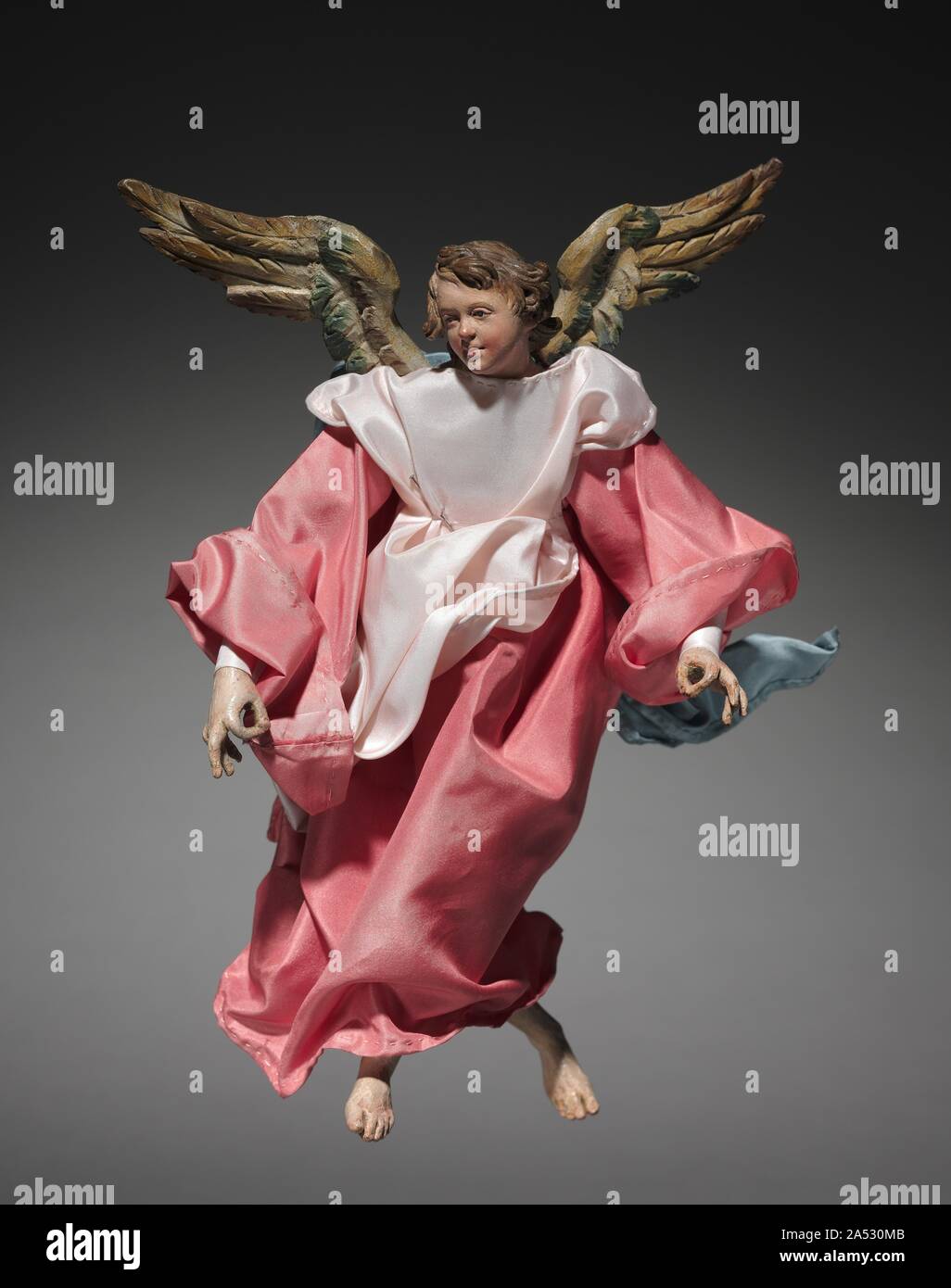 Figure from a Cr&#xe8;che: Angel, 1780-1830. The practice of creating scenes of the Nativity for the home dates from the early 1700s in Italy, where people began to set up doll-like figures of about a foot or less in height. The custom was particularly popular in Naples around 1800, where cr&#xe8;che scenes (cr&#xe8;che means cradle, or crib) included many figures, whose heads and hands of painted terracotta, stuffed cloth bodies, and clothing adapted from contemporary local costumes gave them an amazingly realistic character. Representations of the birth of Jesus can be traced to the first fe Stock Photo