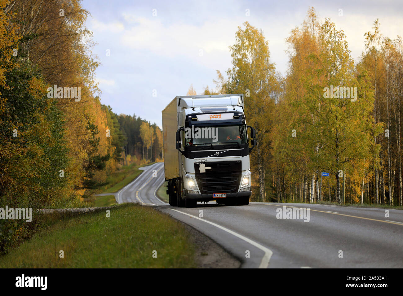 White Volvo FH delivery truck of Posti Kuljetus Oy on highway 52 at autumn dusk. Salo, Finland. October 11, 2019. Stock Photo