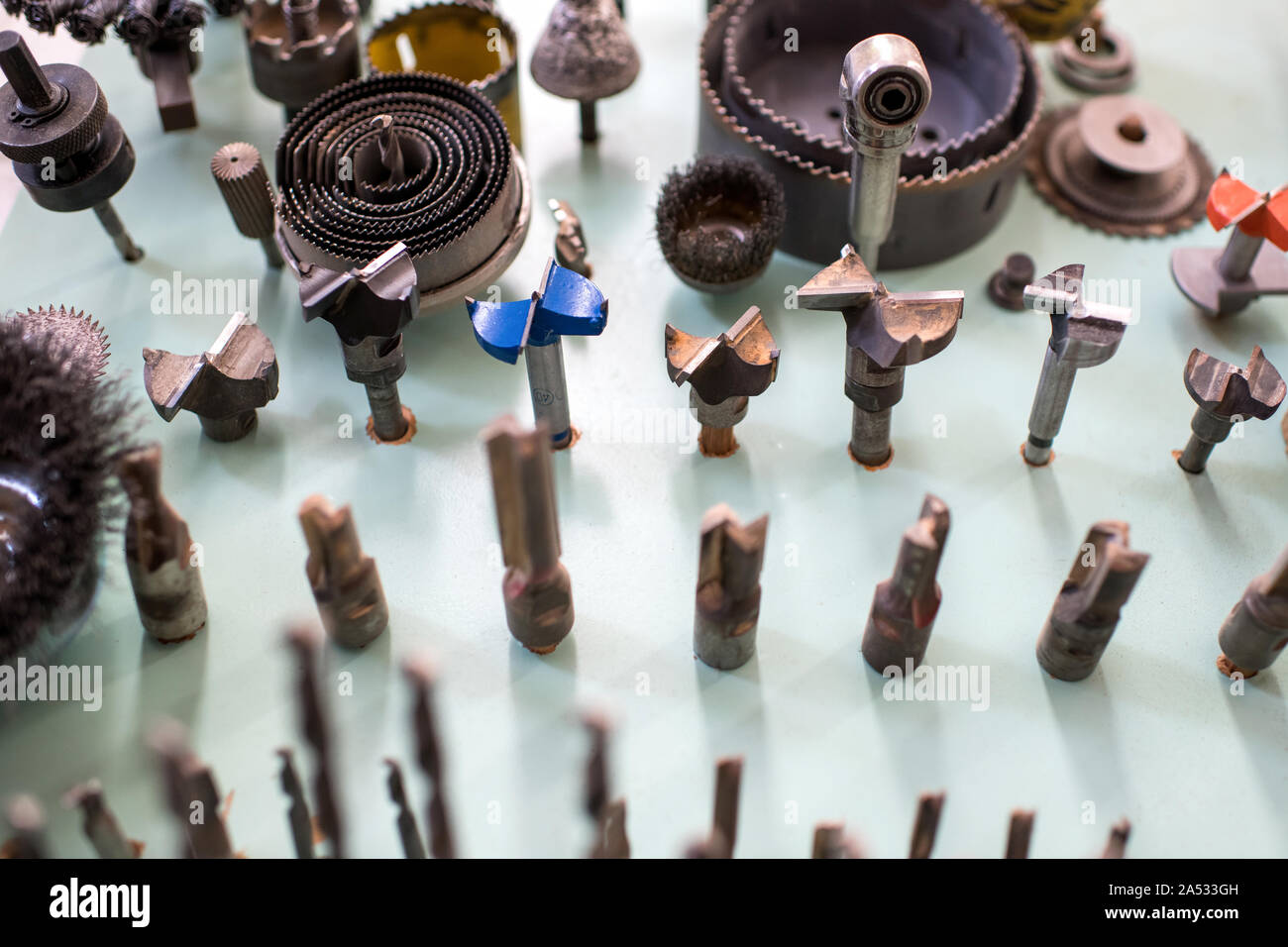 Assorted shapes of drill bits for woodworking neatly stored on a workbench in a carpentry workshop Stock Photo