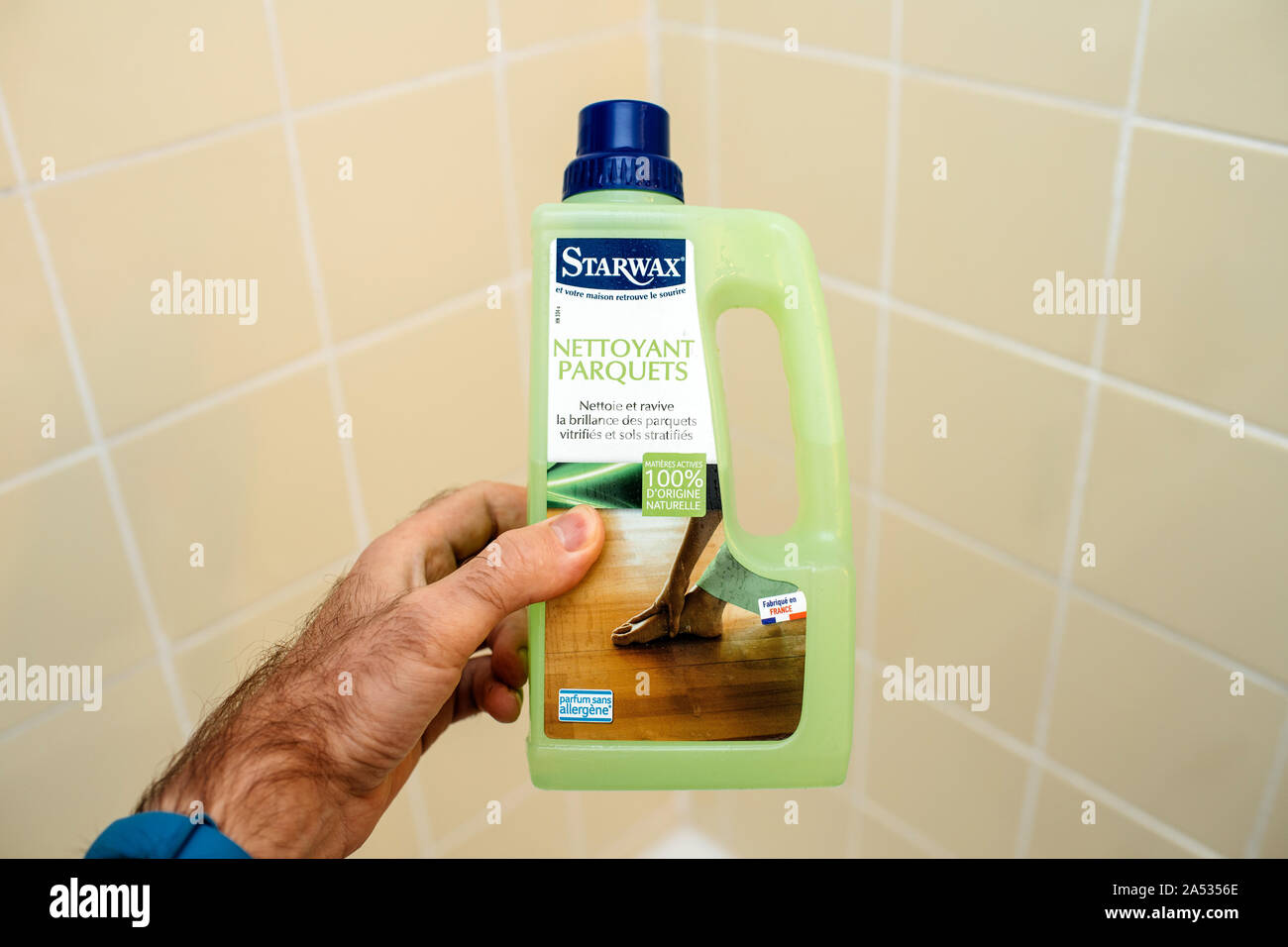 Paris, France - Dec 1, 2017: Male hand holding against bathroom tiles  bootle of Starwax wooden floor cleaning solution from 100 percent bio  organic ingredients Stock Photo - Alamy