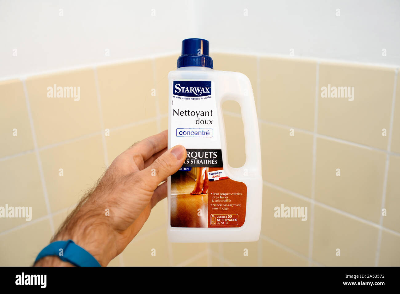 Paris, France Dec 1, 2017 Male hand holding against bathroom tiles