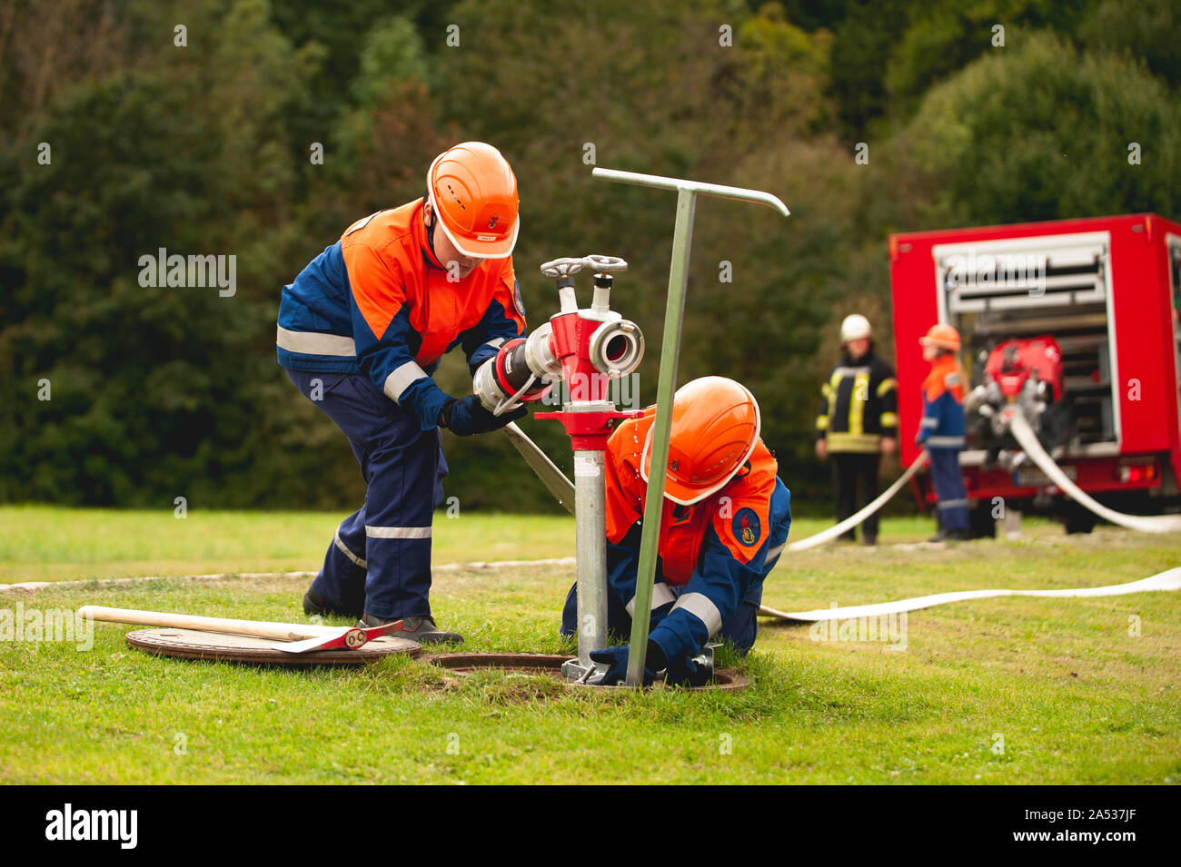 Germany, Niederstetten, Baden Wurttemberg. September 2019 Young firefighters in training, pumping water Stock Photo