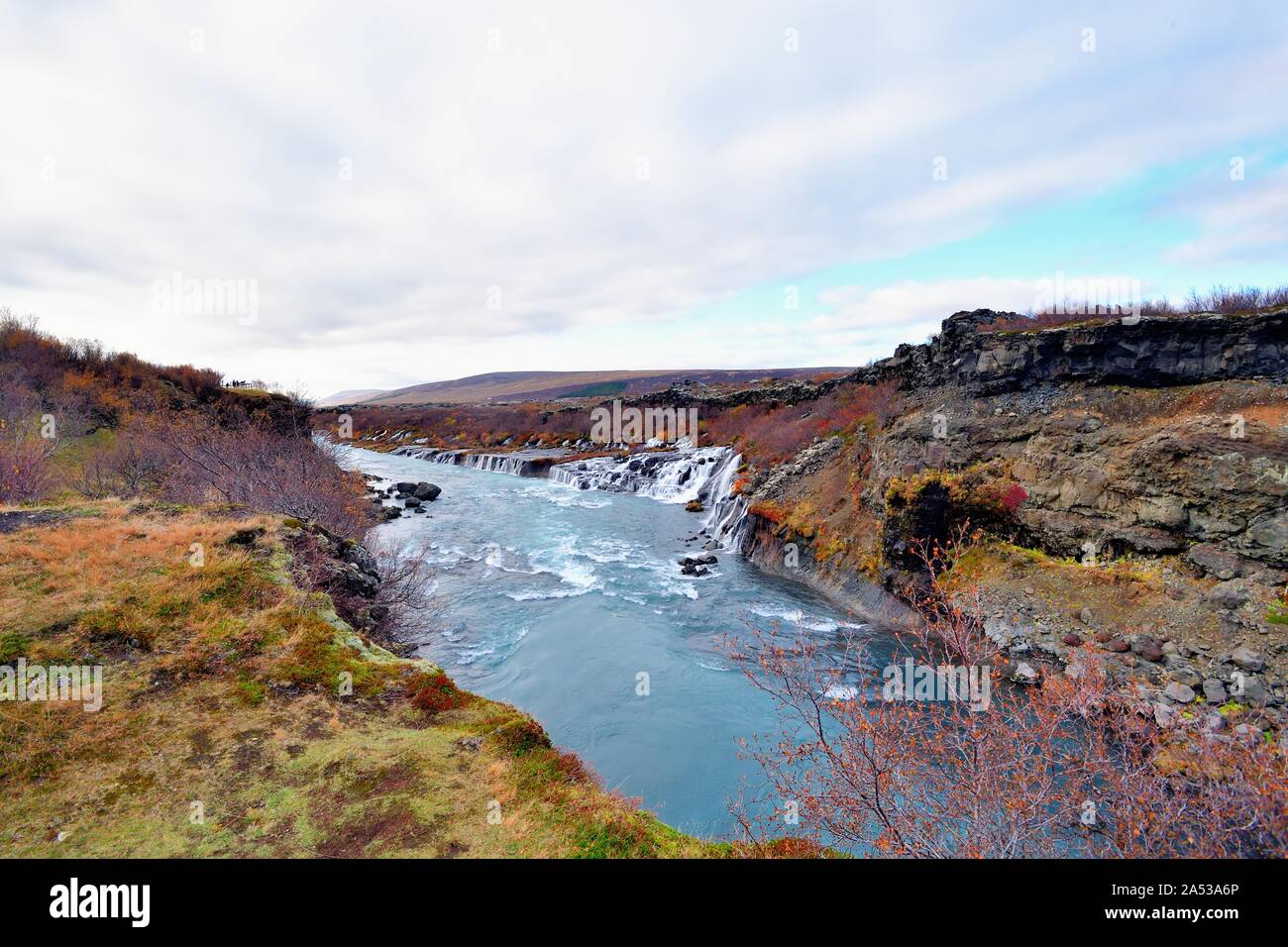 Reykholt, Iceland. The Hraunfosser waterfall. Multiple water flows from the mountains through lava and under moss and lichen and into the Hvita River. Stock Photo
