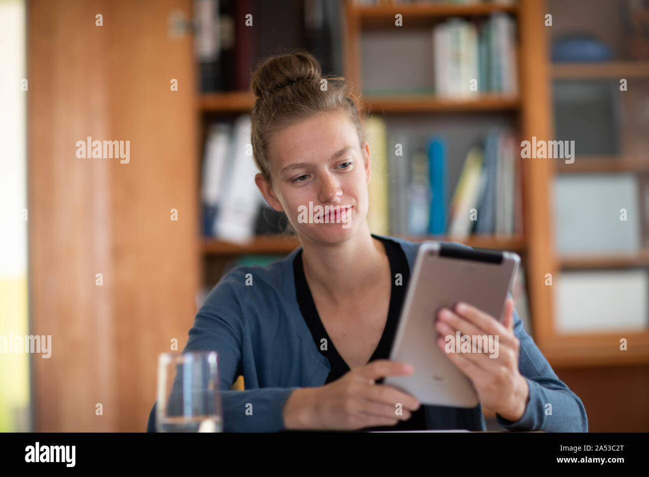 student learning in a library with tablet Stock Photo