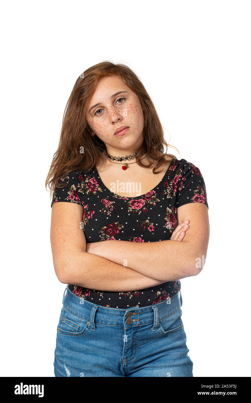 Vertical studio shot of a very irritated pre-teen girl with her arms crossed isolated on white. Stock Photo