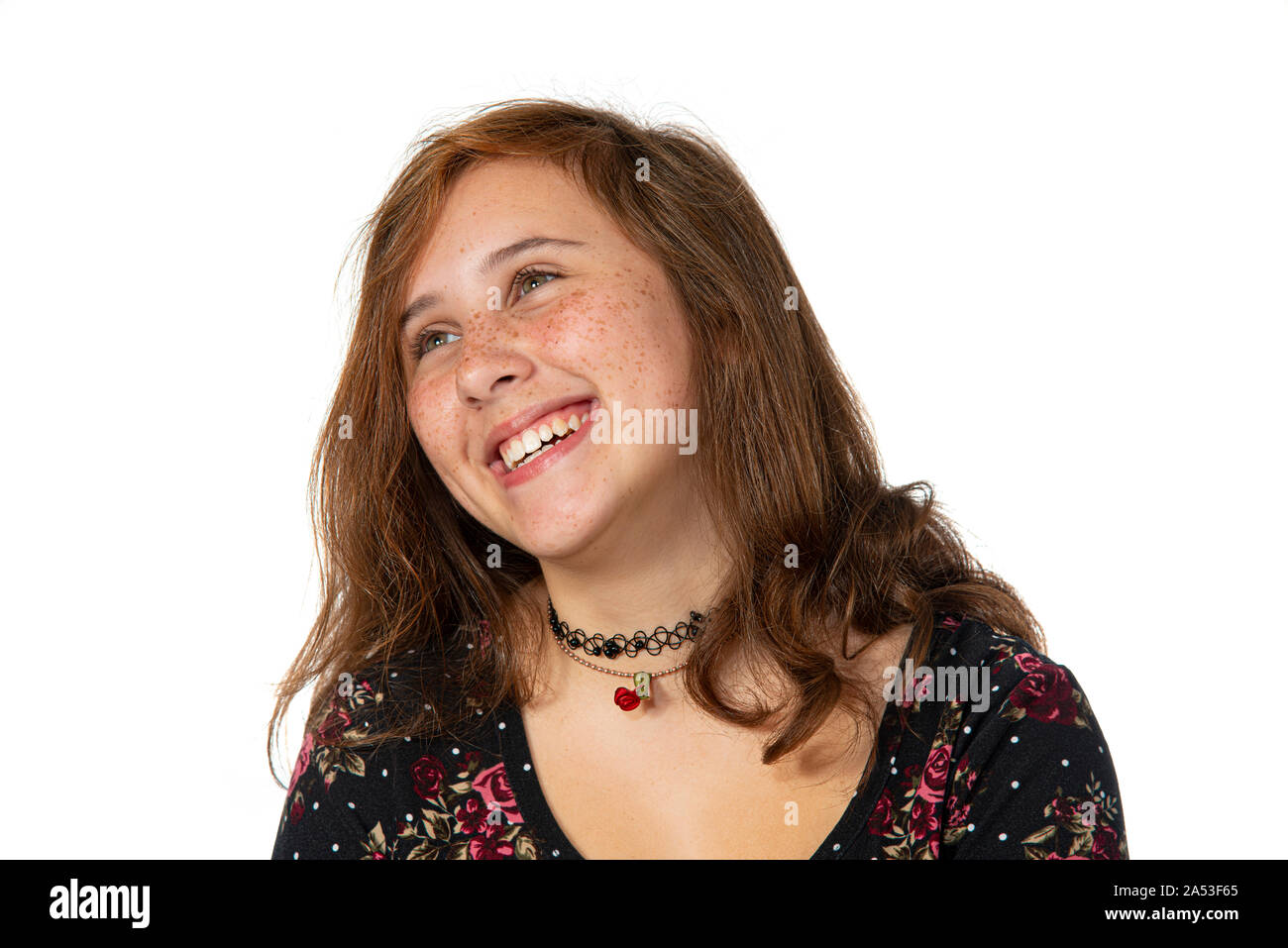 Horizontal studio shot of a laughing pre-teen girl with freckles isolated on white with copy space.  Shot from the chest up. Stock Photo