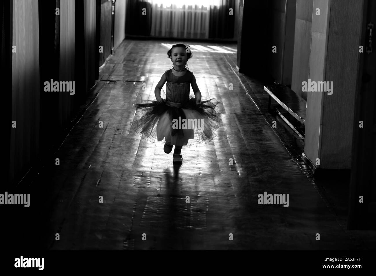 KHARKIV, UKRAINE - MARCH 6, 2019: Cute little girl dreaming of becoming a ballerina. Child girl in a white tutu dancing. Baby girl is studying ballet. Stock Photo