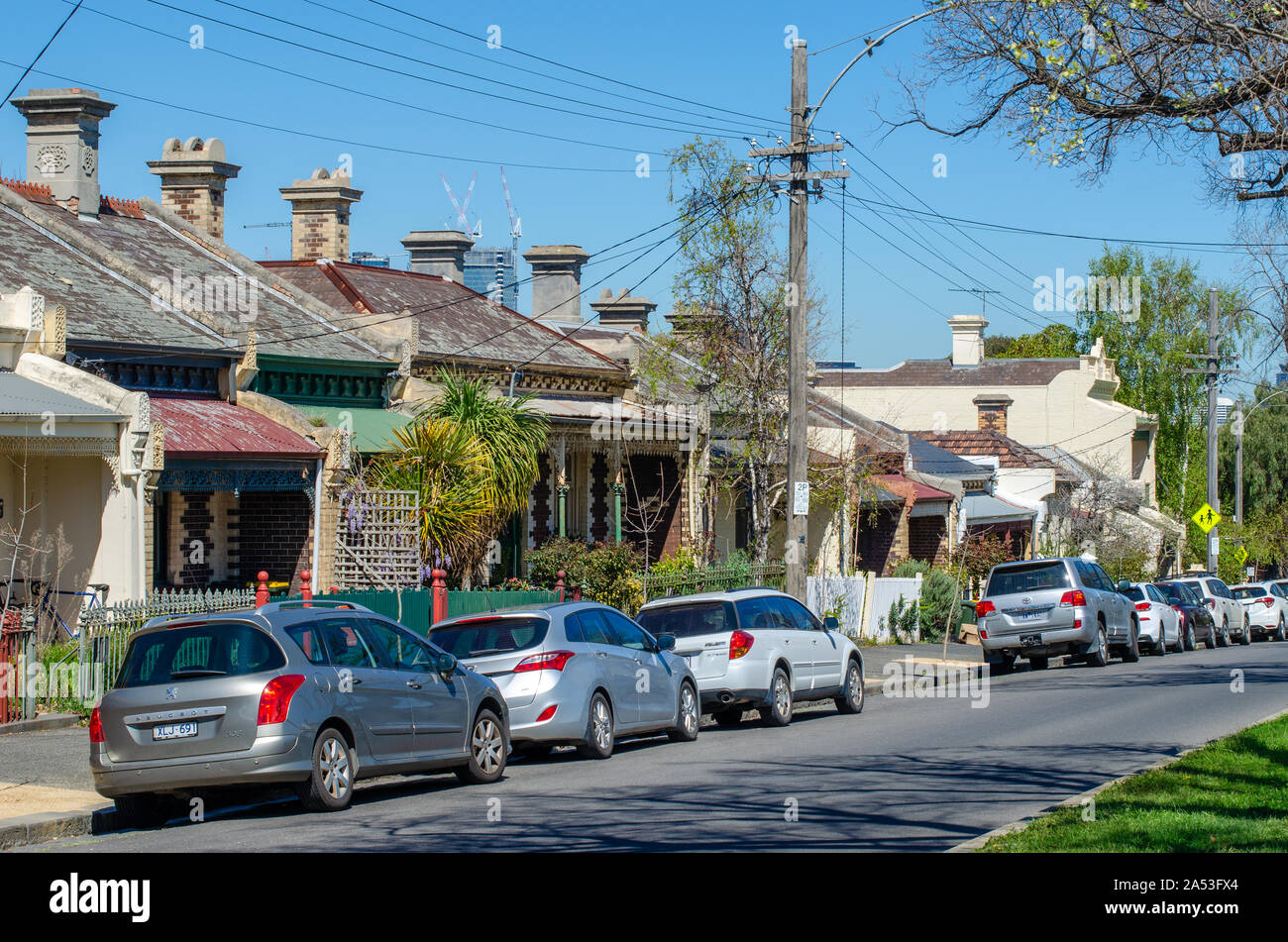 Cars parked along Melbourne's suburban street with Australian historical residential houses. North Melbourne, Victoria,  Australia. Stock Photo