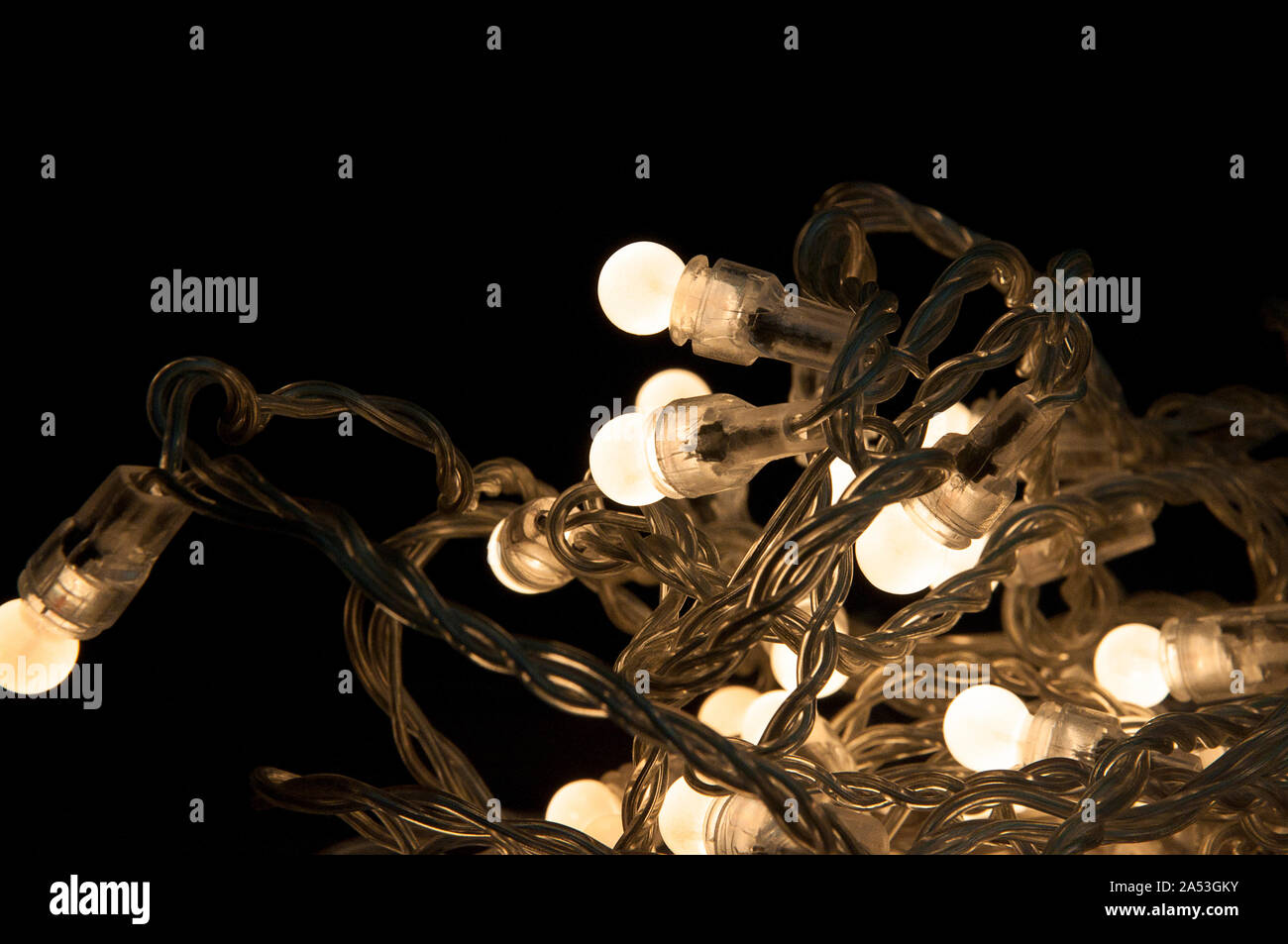 Closeup_chain of white lights_knotted_black background_by jziprian Stock Photo