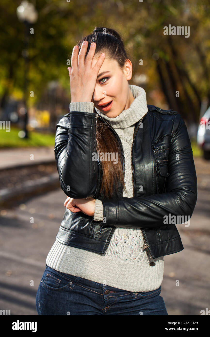 Portrait of a young beautiful brunette woman in a black leather jacket ...
