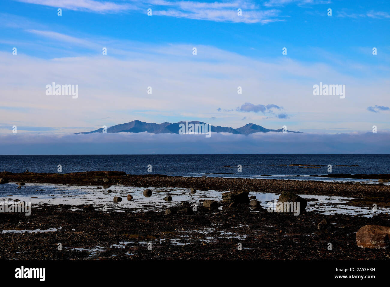 Isle of Arran shrouded in low cloud from Seamill beach Scotland Stock Photo