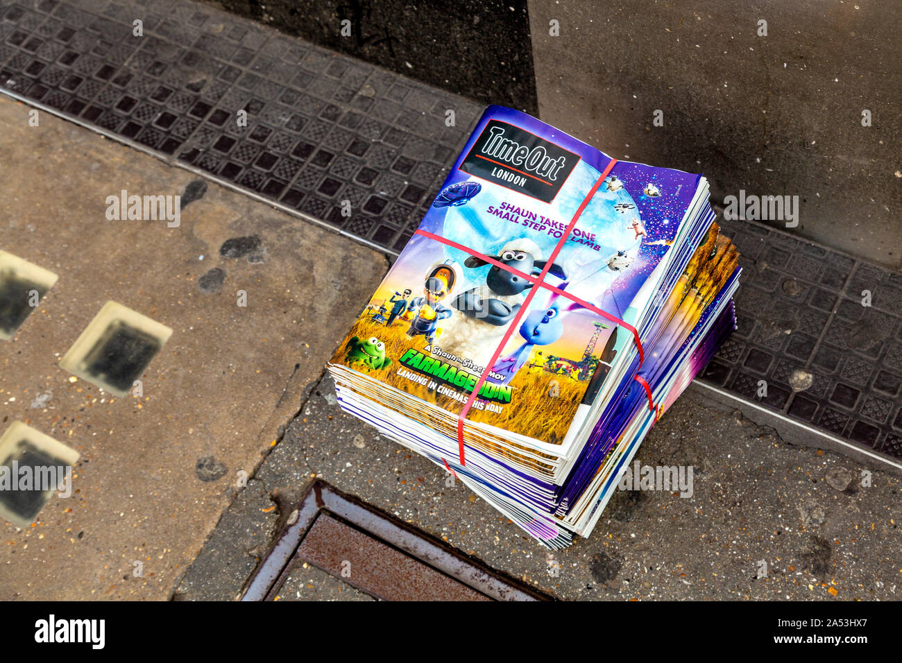 A pile of free TimeOut London magazines on the ground, London, UK Stock Photo