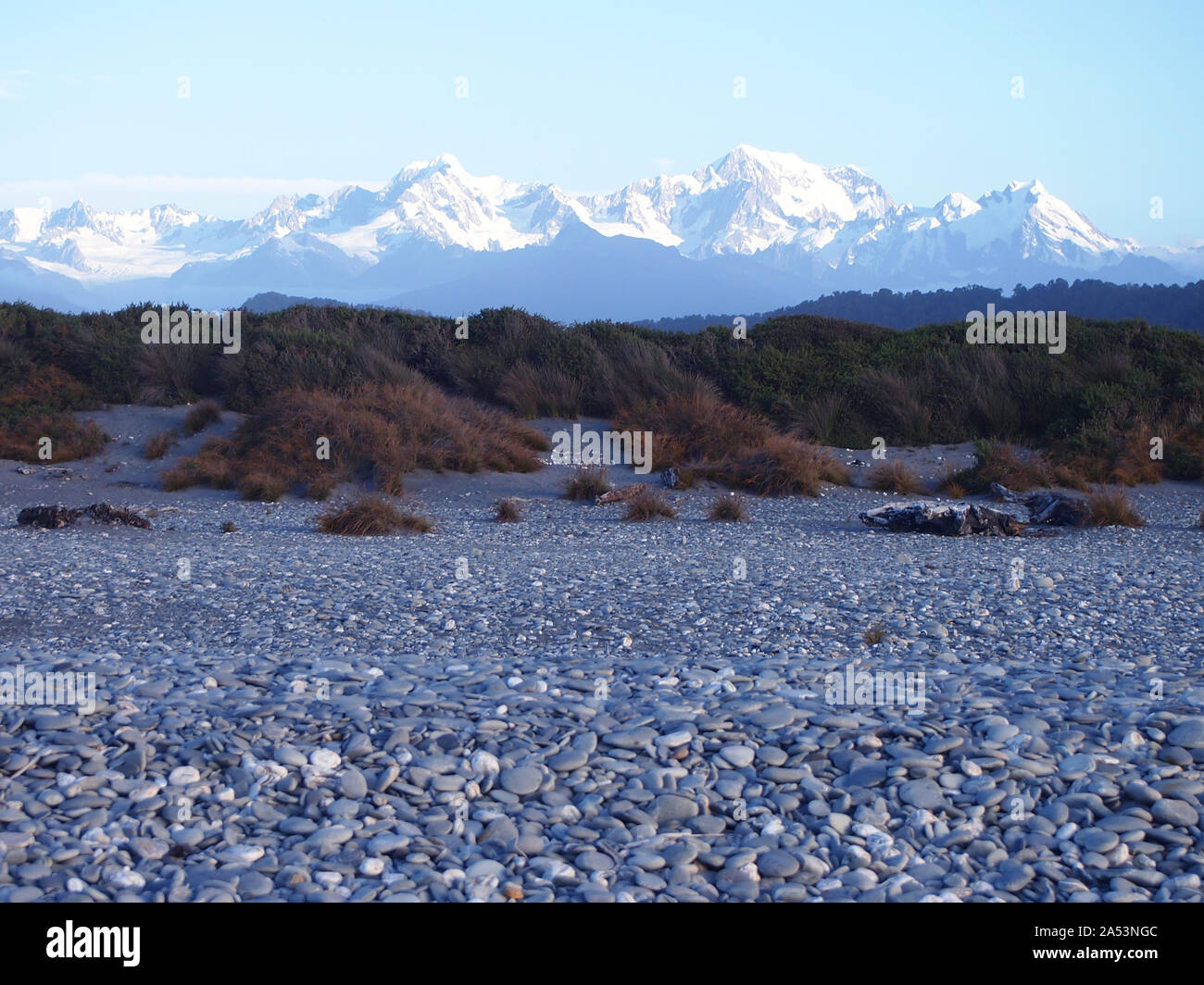 Snow-capped Southern Alps over a beach in South Island West Coast, New Zealand Stock Photo