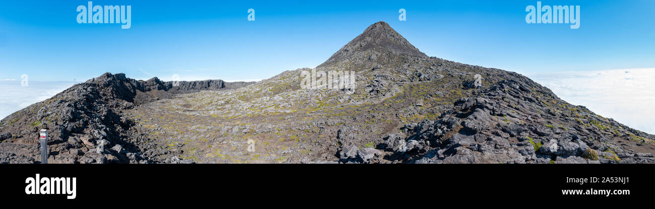 Large panoramic view of the pit crater rim and the pinnacle of the stratovolcano Mt Pico on Pico Island of the Azores. Stock Photo