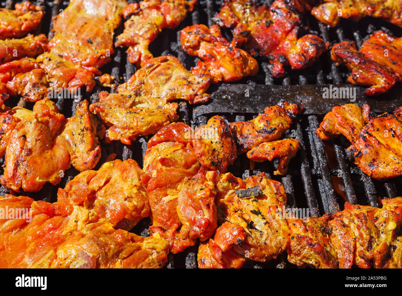 marinated chicken pieces grilling on a charcoal barbecue Stock Photo